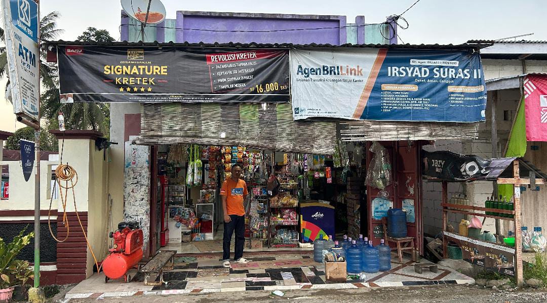 Sudirman H. Nadir berpose di depan warung kelontong miliknya di Dusun Tujuang, Desa Mattirowalie, Kecamatan Kindang, Kabupaten Bulukumba, Jumat (1/8). Kehadiran jaringan internet Indosat membuat Sudirman mampu memperluas usahanya dan melayani transaksi digital bagi warga sekitar. (Foto : Anto).