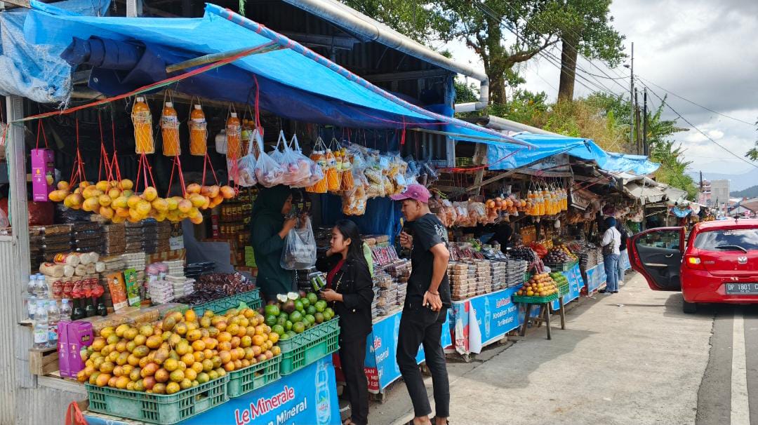 Wisatawan menelusuri deretan buah segar di Sentra UMKM Malino, menikmati suasana khas dataran tinggi sambil memilih oleh-oleh, Minggu (27/08/2025). (Foto: Mardianto/Kabareditorial.com)