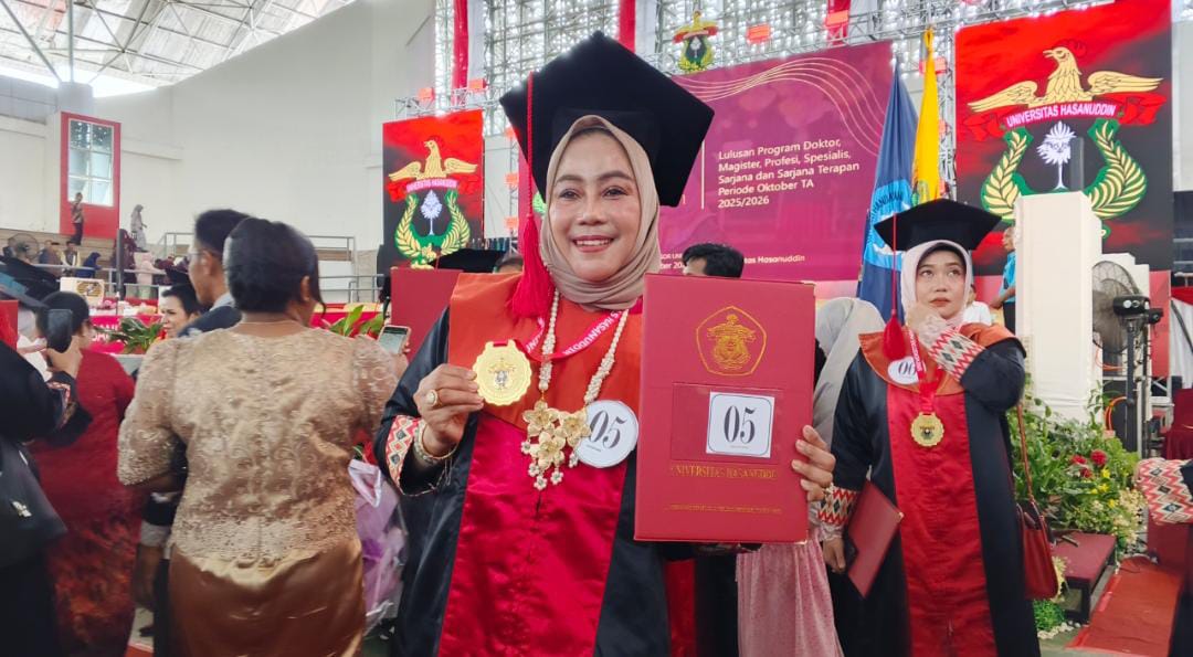 Kepala Dinas Perindustrian, Perdagangan, Koperasi dan UKM Provinsi Kaltara, Dr. Hj. Hasriyani, SH., MM berpose sambil memperlihatkan medali alumni dan piagam kelulusan usai proses wisuda di JK Arenatorium Unhas, Senin (27/10/2025). (Foto : Anto/kabareditorial.com)